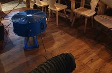 Warmluftschlauch und Ventilator im Chalet-Innenraum während der thermischen Behandlung.